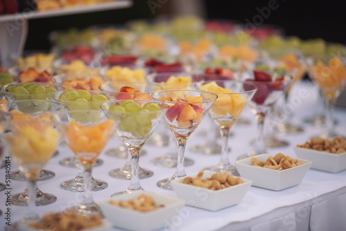 Catering on wedding. Wedding banquet table. Sweet table with fruit. Fruit bar on party. Delicious fruits appetizers  desserts on stand  modern sweet tab.