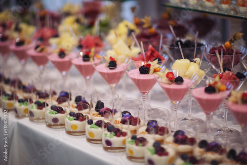 Catering on wedding. Wedding banquet table. Sweet table with fruit. Fruit bar on party. Delicious fruits appetizers. Tasty desserts  cakes and pastry on the wedding sweet buffet.