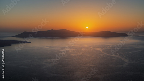 Amazing landscape with a beautiful sunset on Thirasia island viewd from Santorini, Greece photo