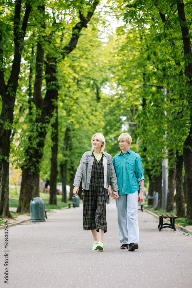 Girl with beloved person taking stroll among park zone in town Girl with beloved person taking stroll among park zone in town