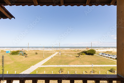 The view from the hotel room on a green lawned area and ocean beach photo