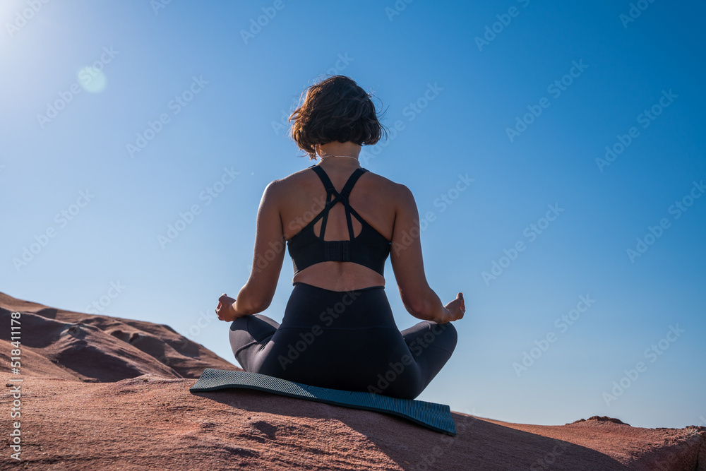 Calm woman meditating at the sandy beach with amazing views Calm woman meditating at the sandy beach with amazing views
