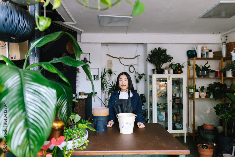 Professional flower employee working in spacious garden store Professional flower employee working in spacious garden store