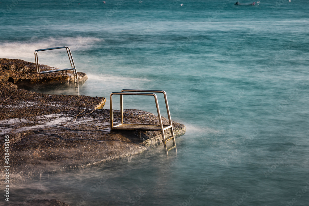 metal ladders to ocean water in long expo metal ladders to ocean water in long expo