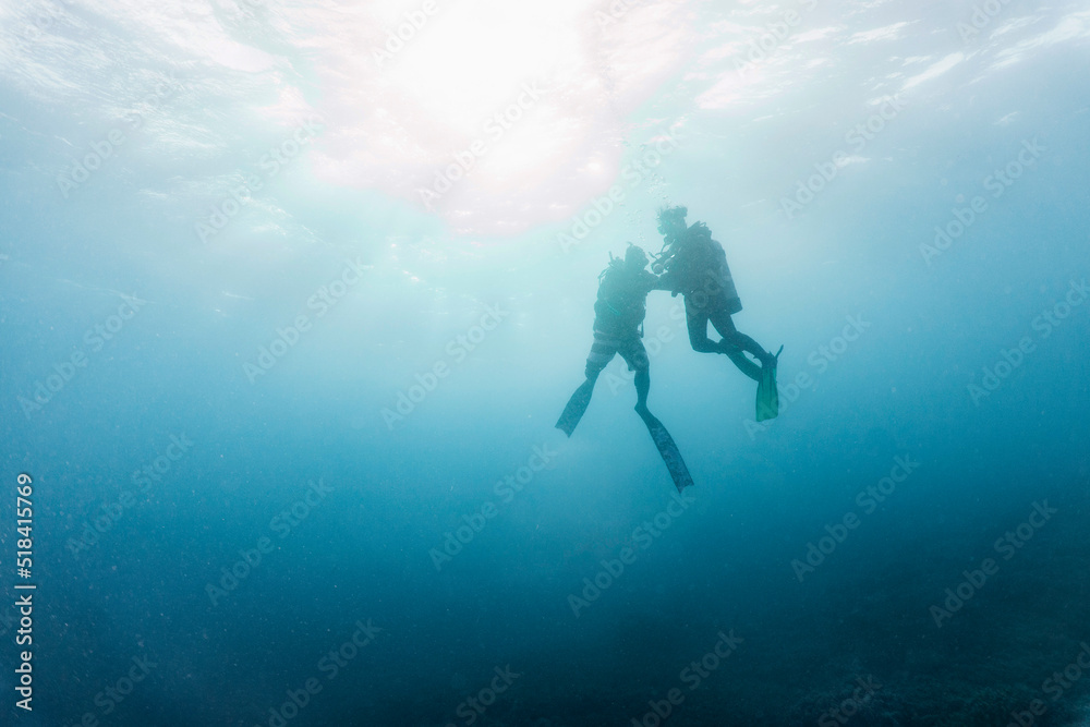 couple diving in the clear water at the Tubbataha Reef couple diving in the clear water at the Tubbataha Reef