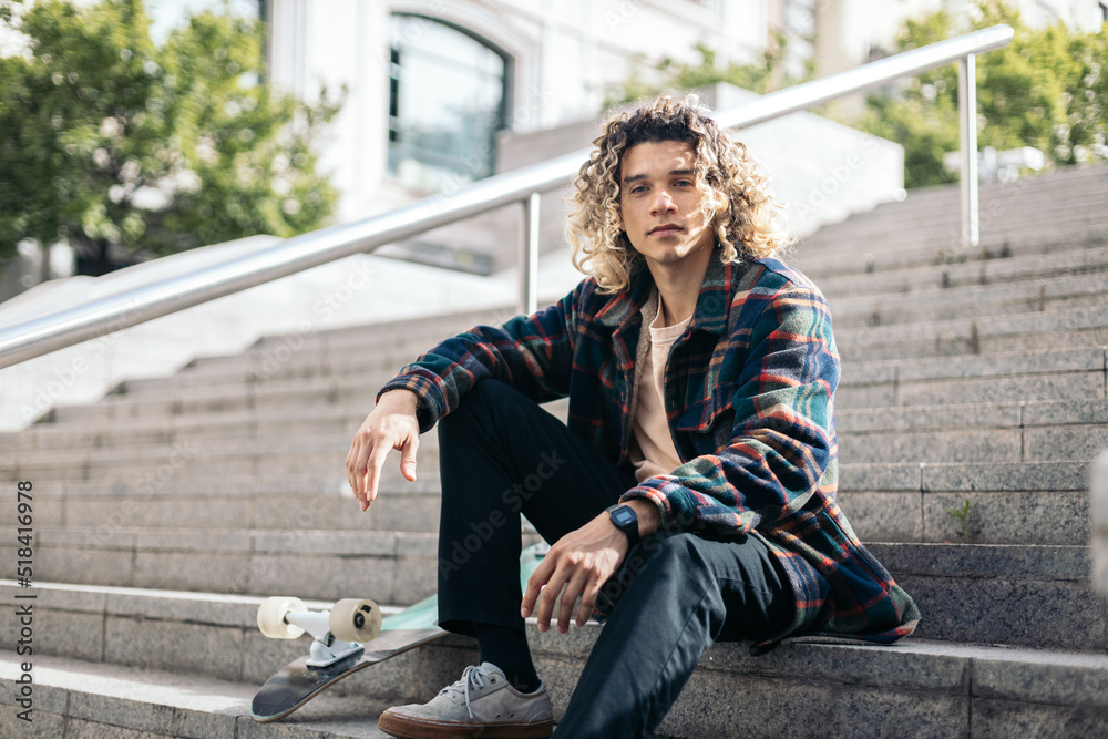 Skateboarder resting sitting on some steps Skateboarder resting sitting on some steps