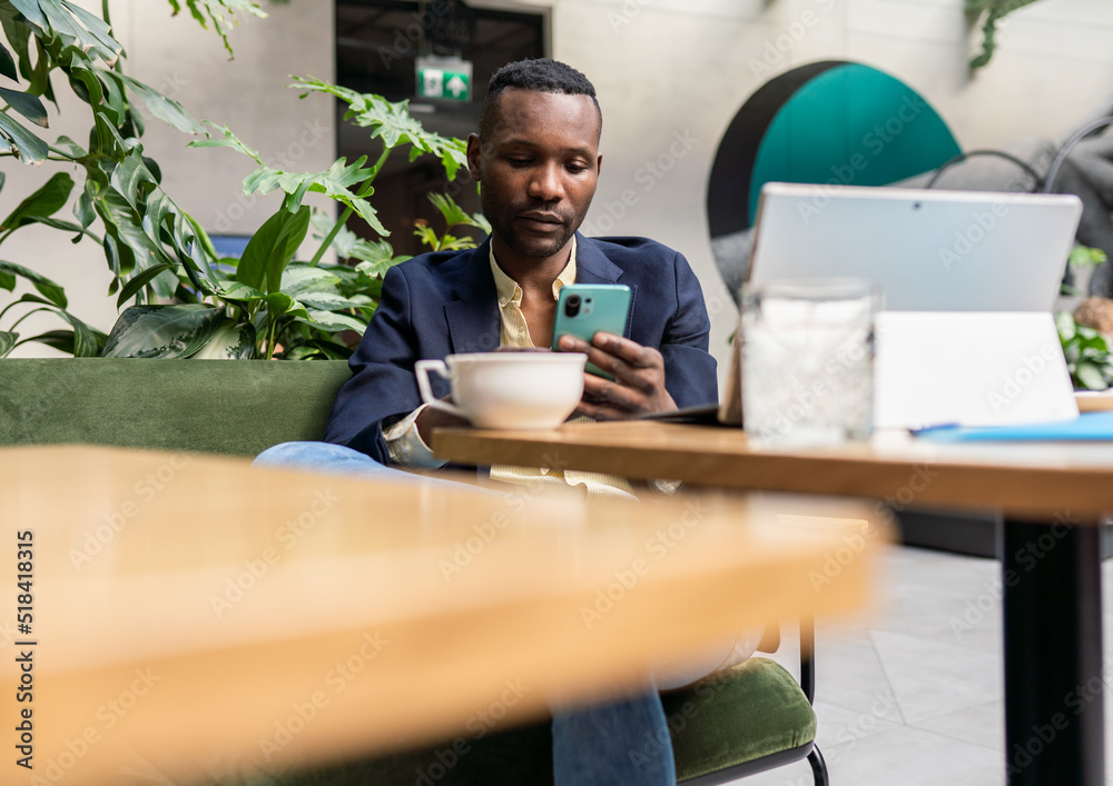 Entrepreneur Using Phone At Cafeteria