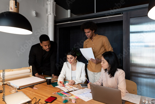 Multiracial colleagues discussing graphs together photo