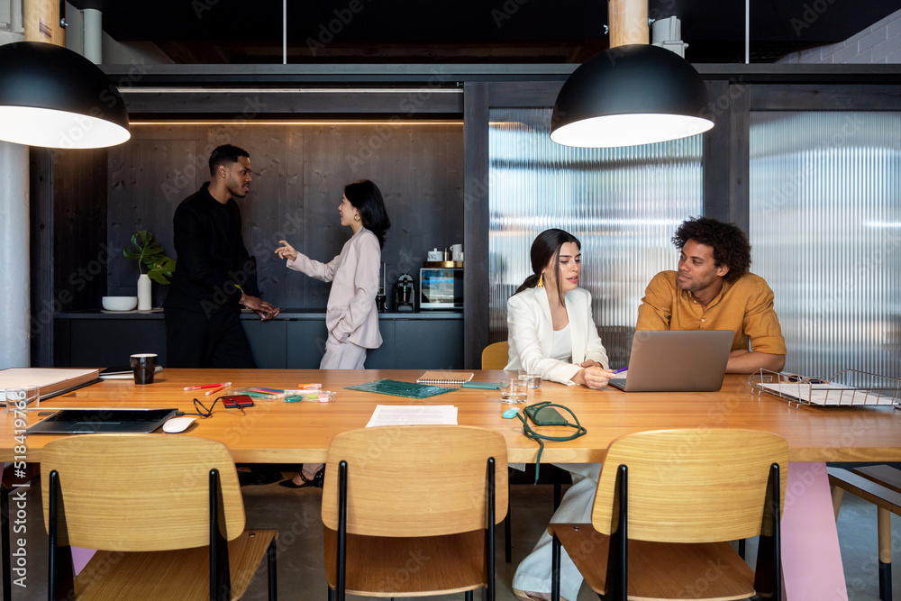 Diverse coworkers speaking in workplace Diverse coworkers speaking in workplace