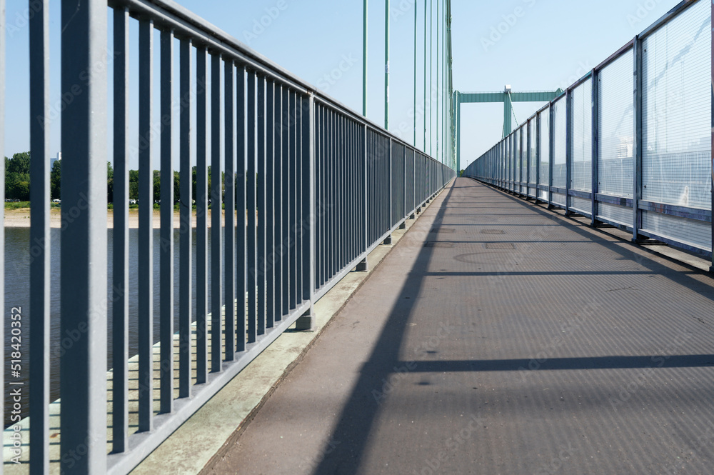 footpath of a highway bridge over the rhine separated from the roadway by glass noise barriers