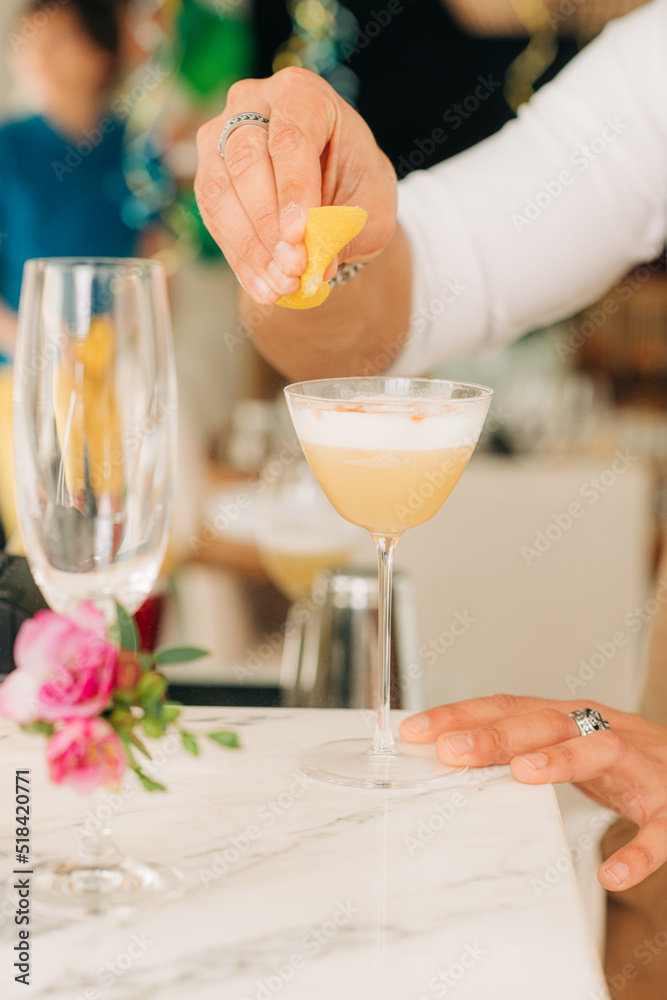 Male hands adding lemon juice to a cocktail Male hands adding lemon juice to a cocktail