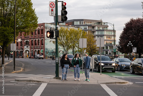 Three friends walking on crosswalk in city. photo