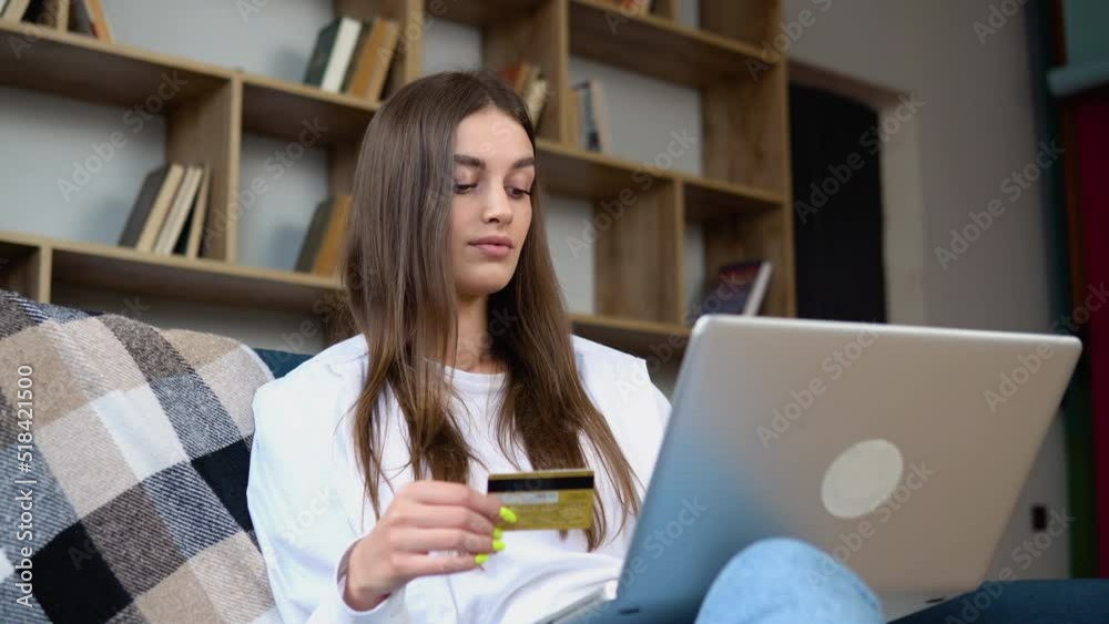 Woman consumer paying for purchase in web store using laptop technology. Female hands of cardholder holding credit card making e bank online payment. Ecommerce website payments concept Woman consumer paying for purchase in web store using laptop technology. Female hands of cardholder holding credit card making e bank online payment. Ecommerce website payments concept