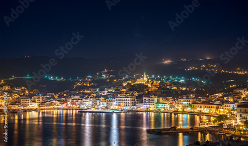 Night long exposure view of Tinos town. Centered the famous church of Panagia, Virgin Mary, illuminated at night. Tinos island Cyclades, Greece. © panosk18