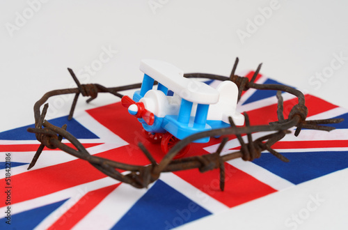 Toy plane, UK flag and barbed wire on a white background.