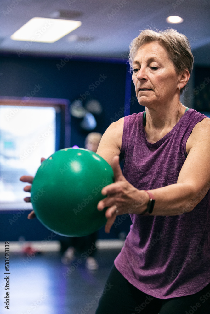 Senior Woman Using Exercise Ball During Workout Senior Woman Using Exercise Ball During Workout