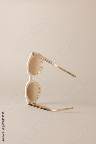 pair of sunglasses on light tan background photo