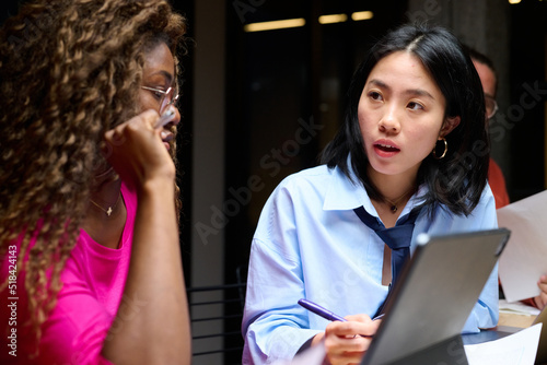 two worried co-workers discussing in evening office.