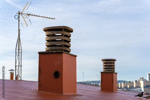 Chimeneas y antena en el tejado de un edificio.