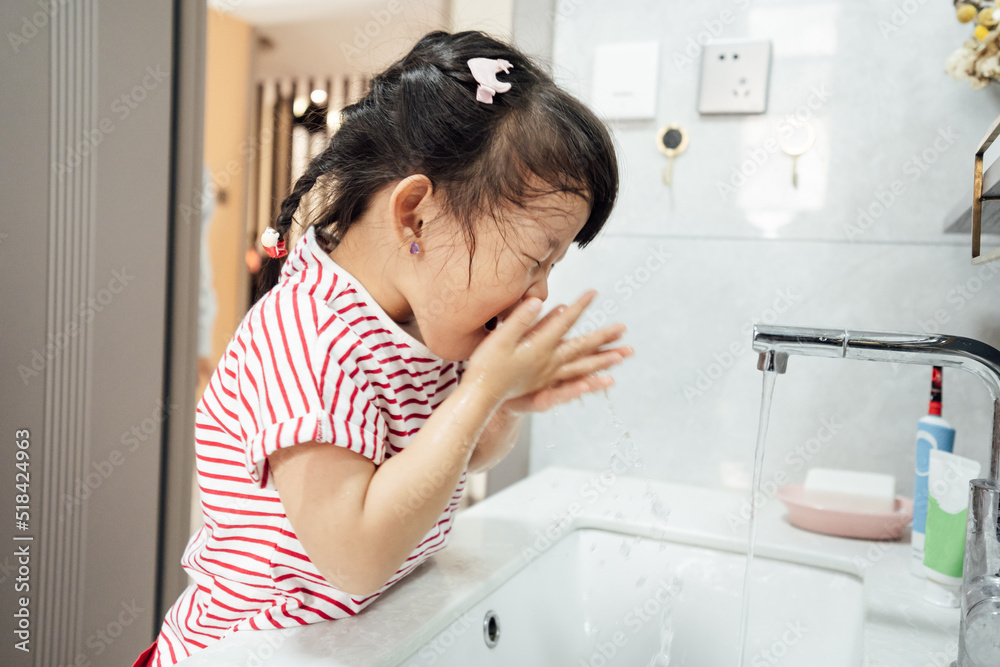 Cute little girl washing face in bathroom Cute little girl washing face in bathroom