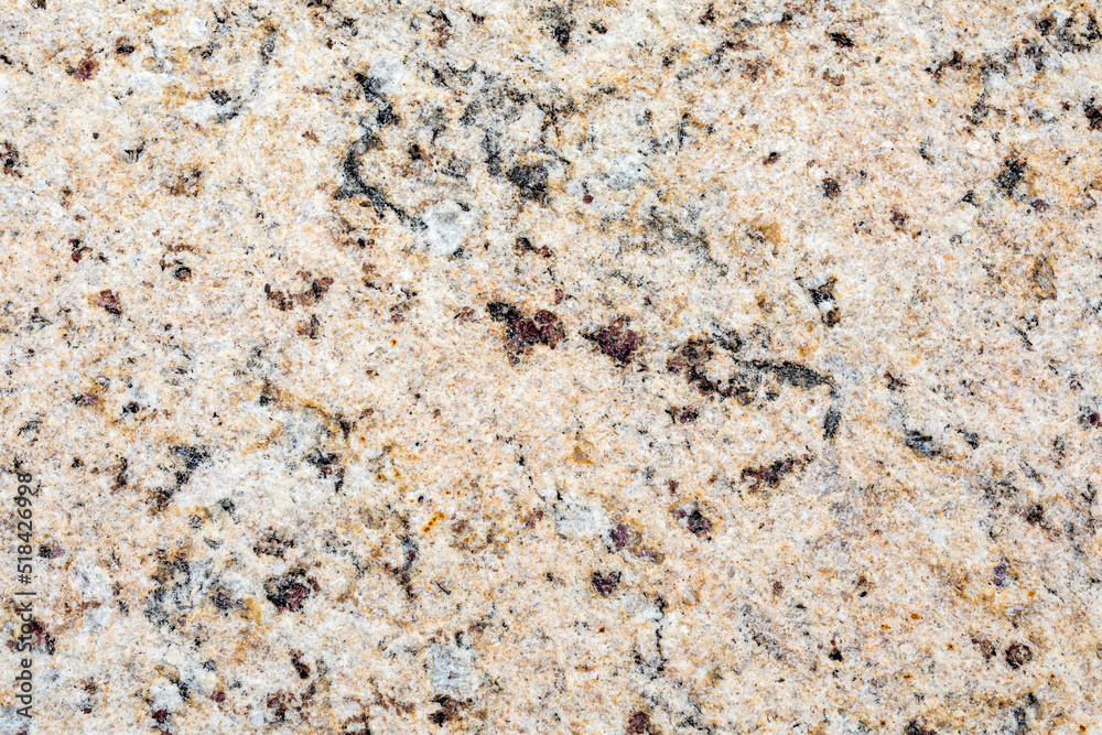 The texture of natural granite stone. The background of pinkish-beige stone interspersed with yellow, brown, gray and black tones. The texture of natural granite stone. The background of pinkish-beige stone interspersed with yellow, brown, gray and black tones.
