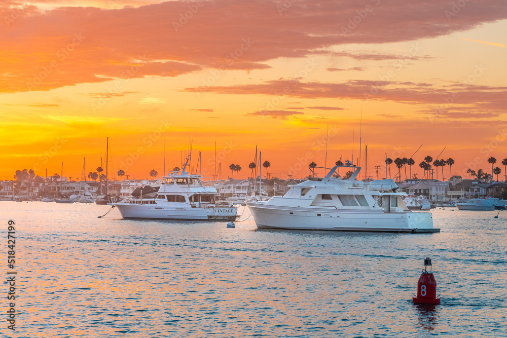 Yachts on the dock in the port against the backdrop of sunset on the ocean. California. Newport Beach
