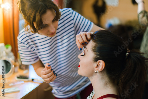 An actress and a make-up artist in front of a mirror