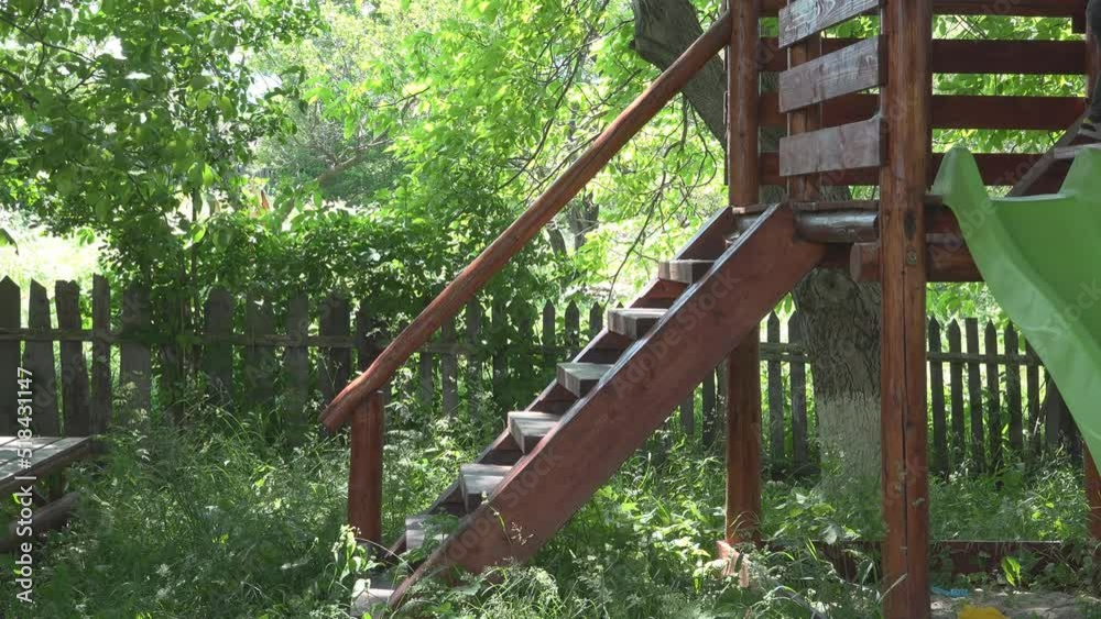Little child climbing the wooden stairs of the playground slide Little child climbing the wooden stairs of the playground slide