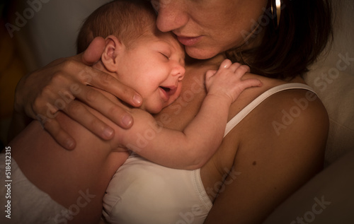 Happy sleepy newborn on mother's arms photo