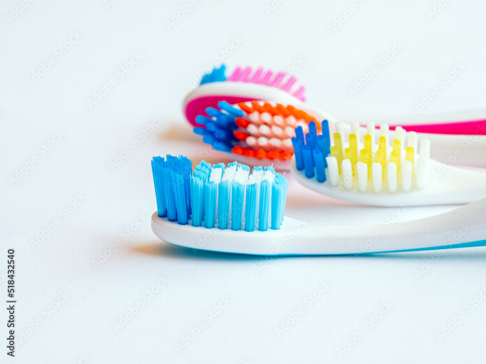 a close up photo of few different color toothbrushes heads a close up photo of few different color toothbrushes heads