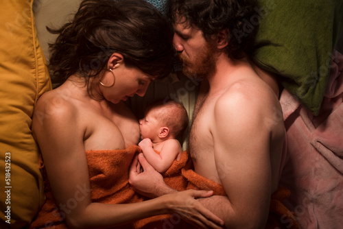 Portrait of loving parents breastfeeding newborn photo
