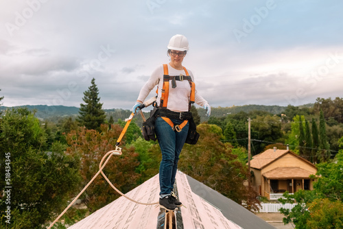 Female roofer working on top roof photo