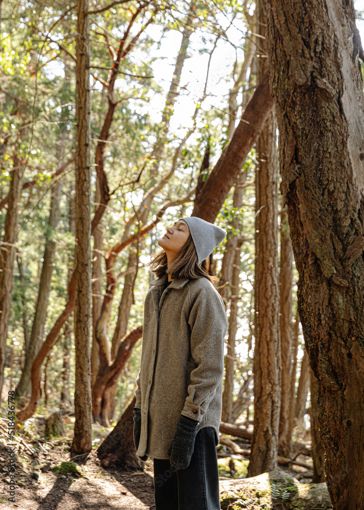 Young woman forest bathing/relaxing in forest Young woman forest bathing/relaxing in forest
