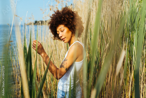 Afro woman stands in the nature photo