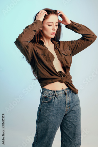 Model in a khaki shirt and jeans moves in the studio photo