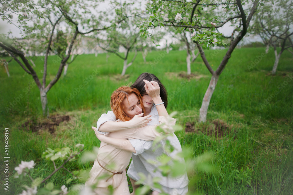 two women contemporary dancers dancing in a blossom garden two women contemporary dancers dancing in a blossom garden