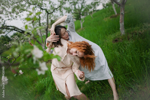 two women contemporary dancers dancing in a blossom garden photo