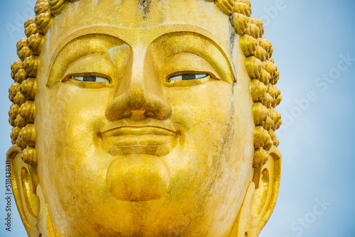 Close up the big golden Buddha statue of Thaksin Mingmongkol, Narathiwat province, Thailand. photo