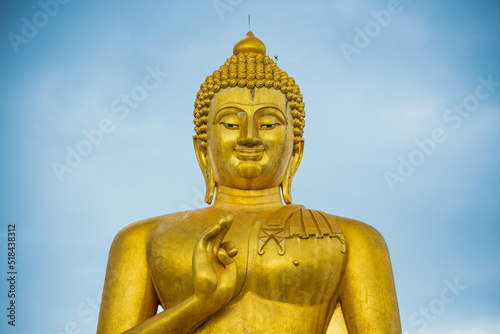 Close up the big golden Buddha statue of Thaksin Mingmongkol, Narathiwat province, Thailand.