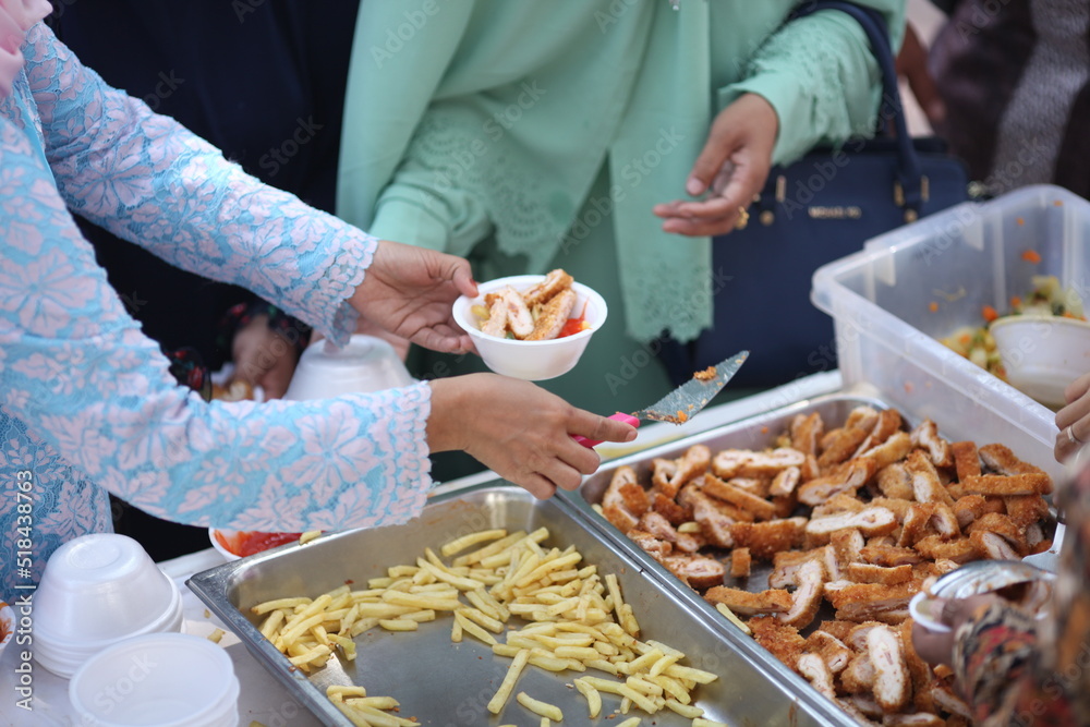 the woman's long shirt holds the bowl with her left hand and the right hand holds the spoon