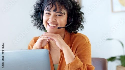 Portrait of a friendly call center agent using a headset while consulting for customer service and sales support in an office. Young sales rep smiling and laughing while working remotely on a laptop photo