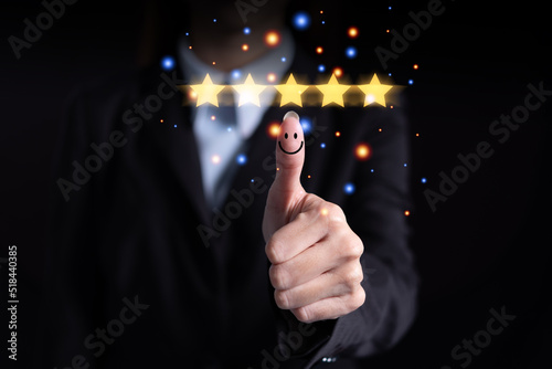 Female hand thumbs up showing excellent customer satisfaction. with 5 star rating graphic symbols on the screen