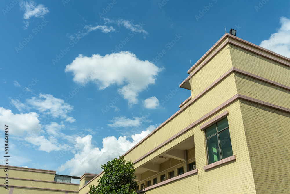 White clouds floating on the roof of the building in summer. Sunny day, sea of clouds, sky and weather material. Landcape of Dongguan, China. 
