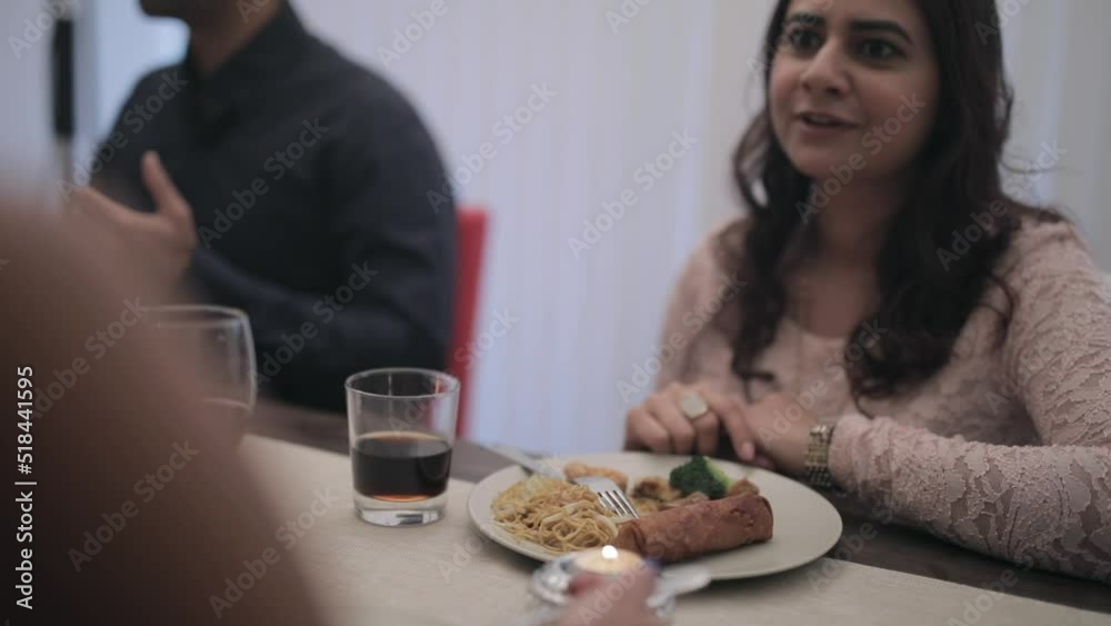 Group having dinner and chatting and smiling and laughing. Slow pan up right to woman talking joyfully Group having dinner and chatting and smiling and laughing. Slow pan up right to woman talking joyfully