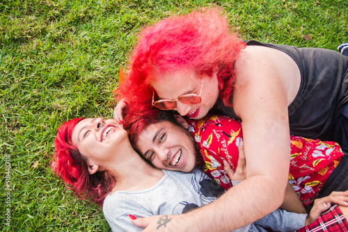 Three goofy trans friends laugh and hug photo