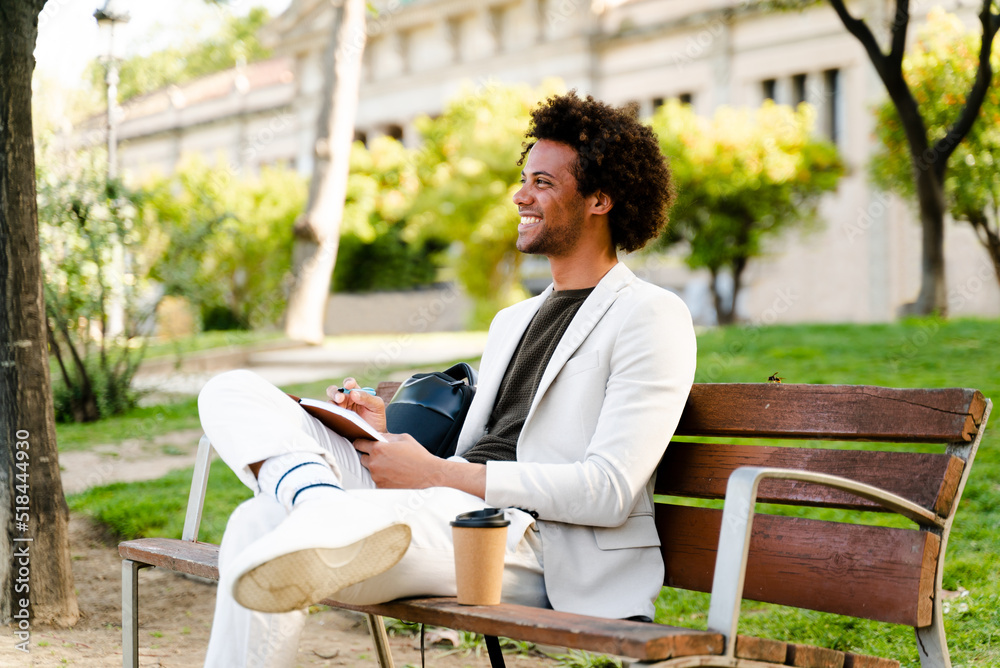 Businessman Writing In A Notebook In A Park