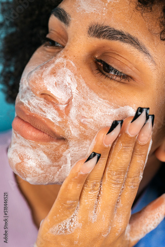 Brown skinned woman cleansing face with handmade soap
