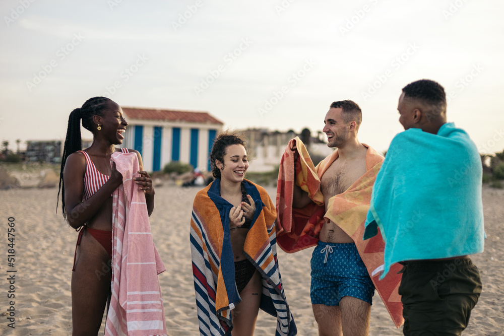 Group of multi-ethnic friends enjoying after a swim in the sea Group of multi-ethnic friends enjoying after a swim in the sea