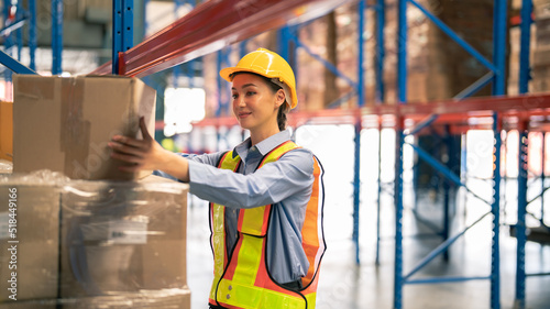 female warehouse worker Work at a distribution center looking at camera Standing at a large warehouse, the new arrival of additional items in the warehouse department. Employees , organize 