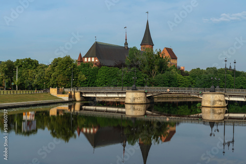 View of the Koningberg Cathedral on Immanuel Kant Island against the background of the bridge over the Pregolya River on a sunny summer day, Kaliningrad, Russia photo